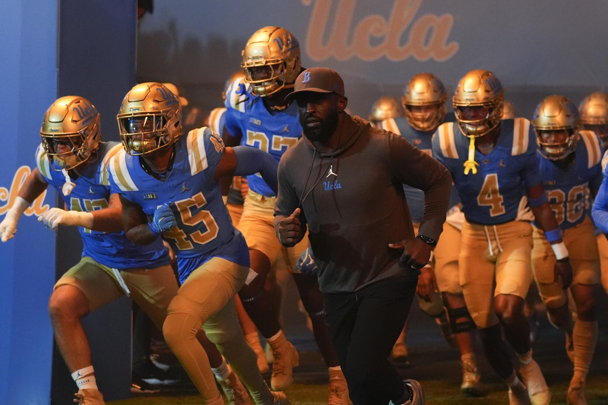 UCLA coach DeShaun Foster leads the Bruins onto the field a game against Oregon at the Rose Bowl on Sept. 28.