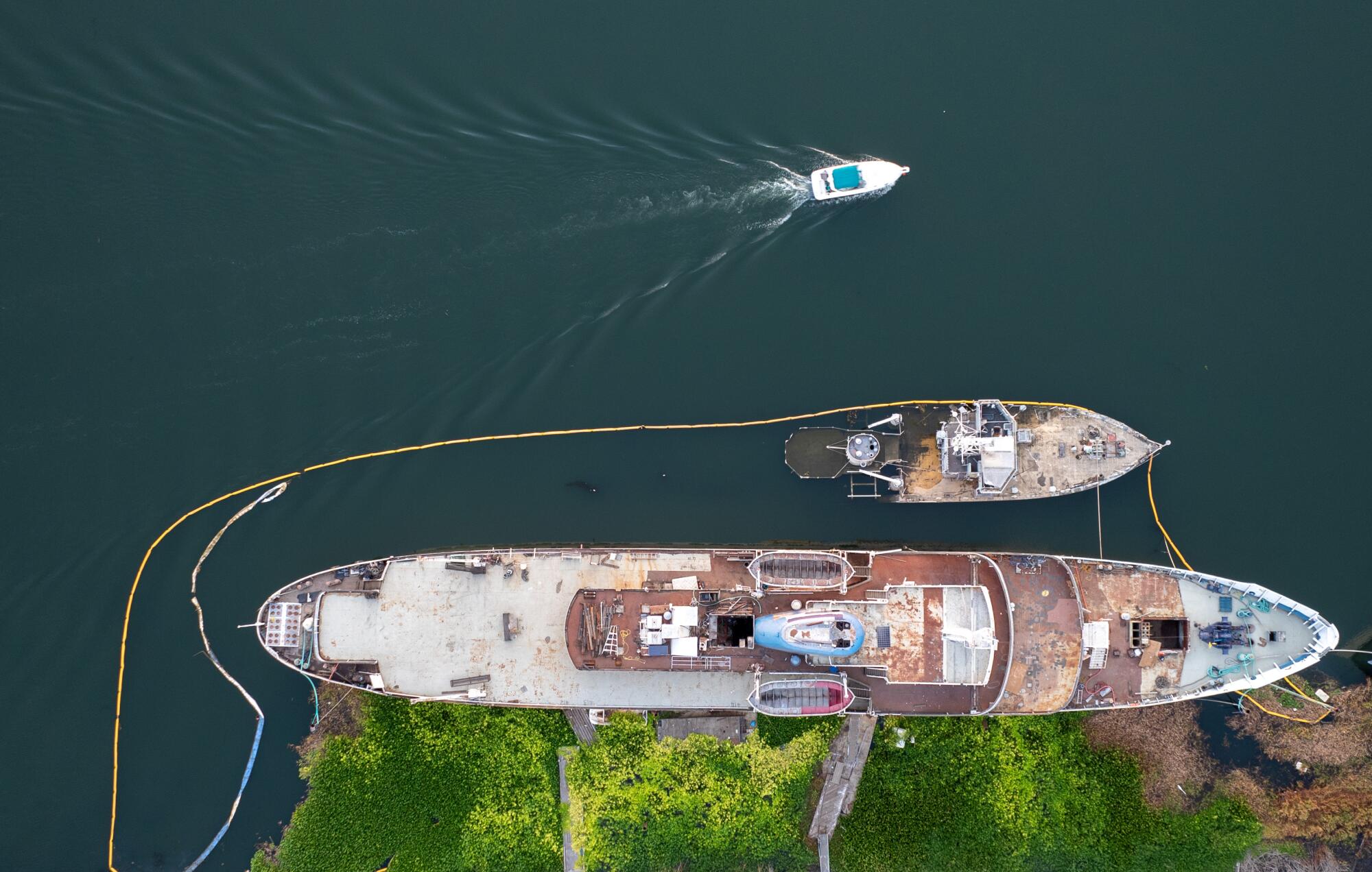 Aerial view of a pleasure craft cruising past the Aurora, which is mired in Little Potato Slough in Stockton. 