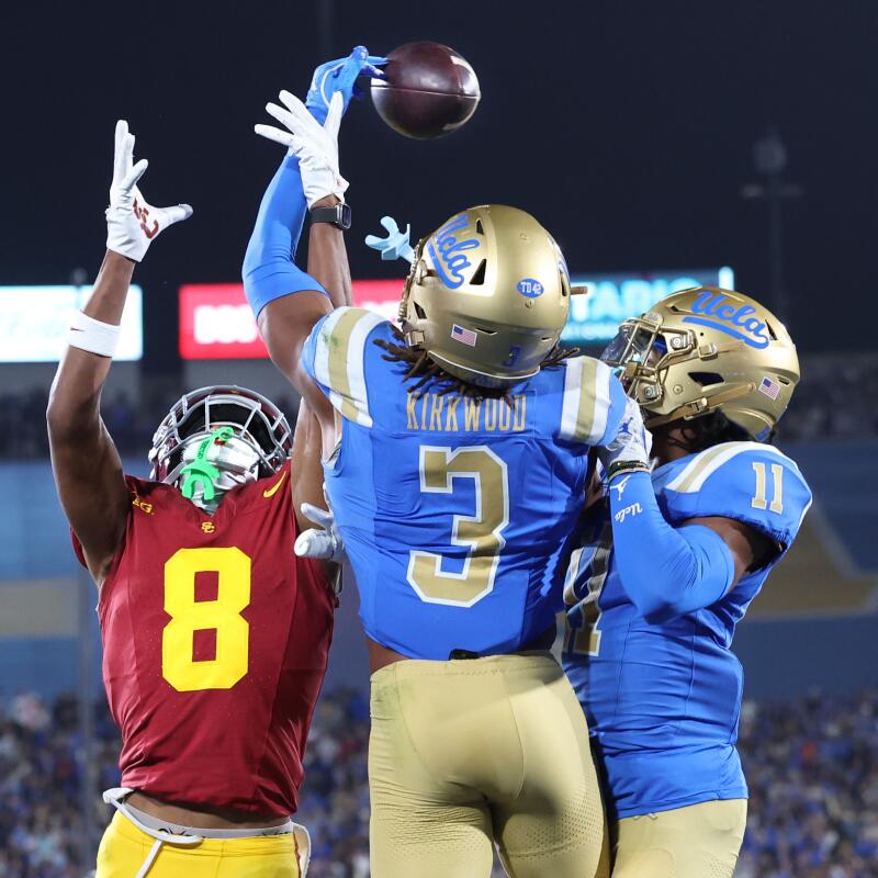 UCLA's Devin Kirkwood (3) and Ramon Henderson (11) prevent USC receiver Jacobi Lane from making a catch in the end zone.