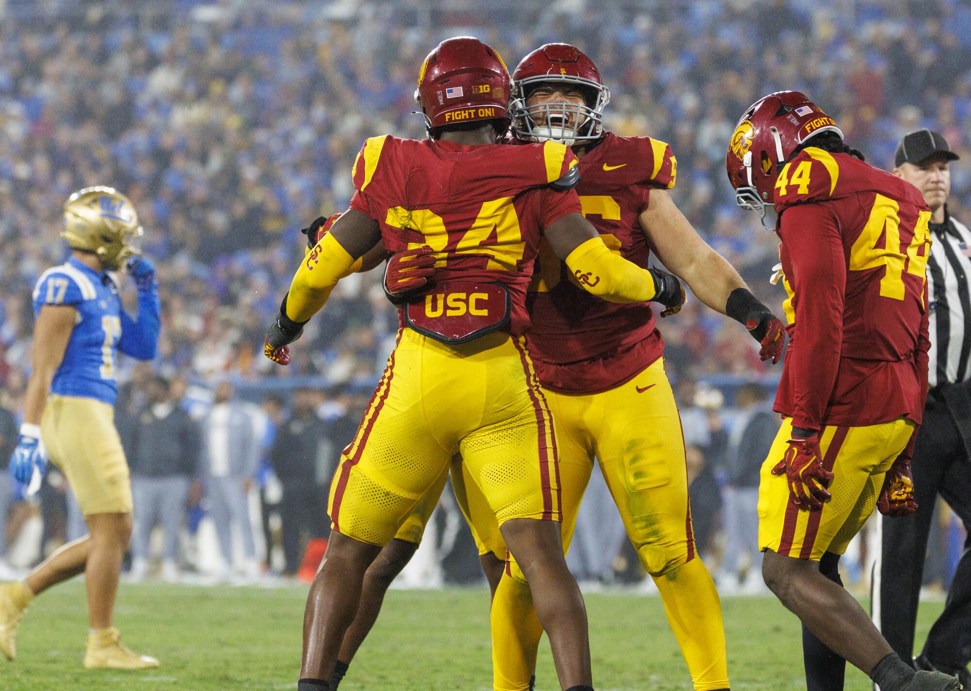 USC defensive linemen Elijah Hughes and Braylan Shelby hug after stopping UCLA late in the fourth quarter