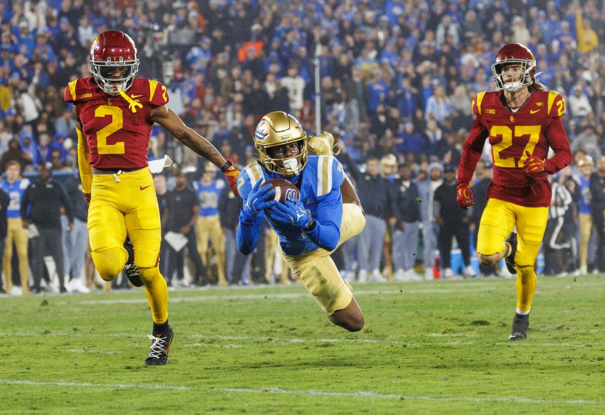 UCLA receiver J.Michael Sturdivant catches a long pass between USC cornerback Jaylin Smith and safety Bryson Shaw