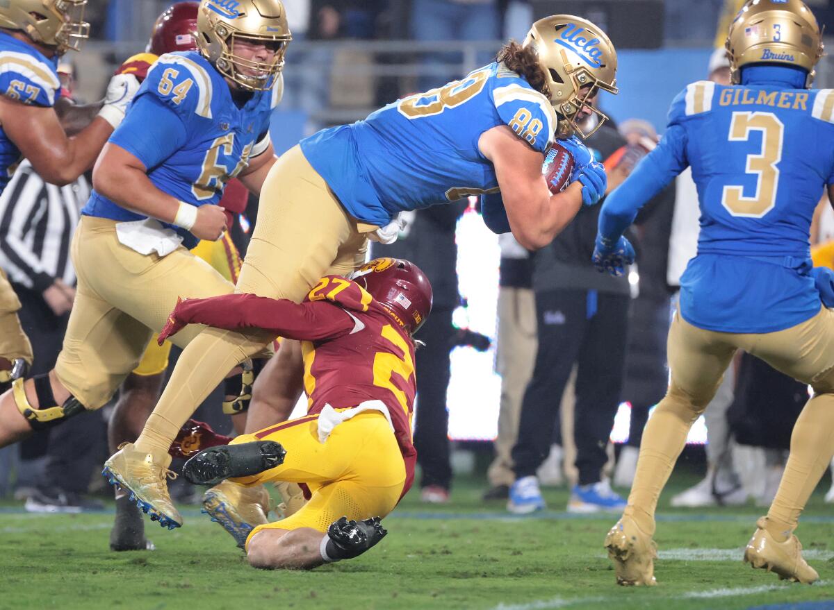 UCLA tight end Moliki Matavao beats USC safety Bryson Shaw to reach the end zone in the third quarter at the Rose Bowl