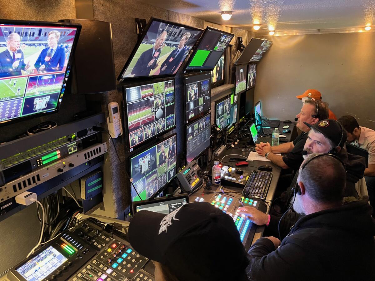 Studio workers with headsets, monitors and other equipment