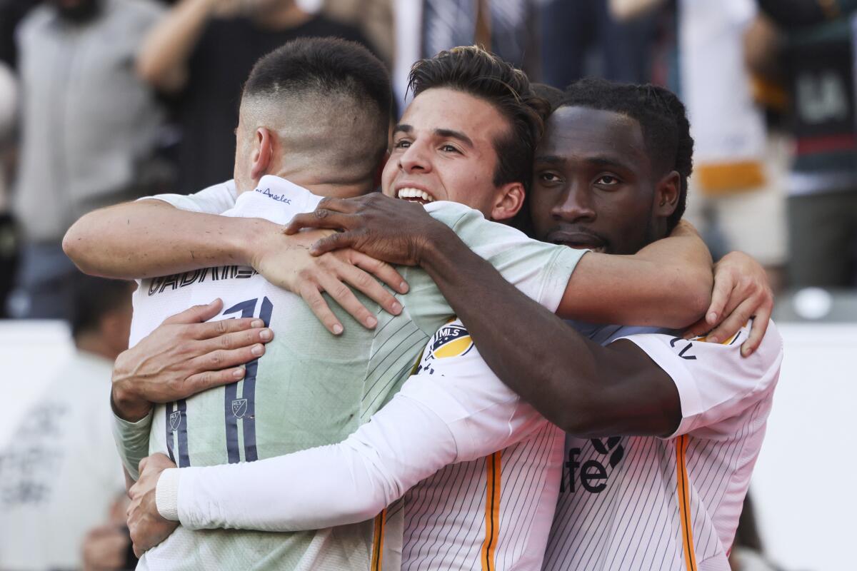 Galaxy's Joseph Paintsil, right, celebrates with teammates Gabriel Pec, left, and Riqui Puig.