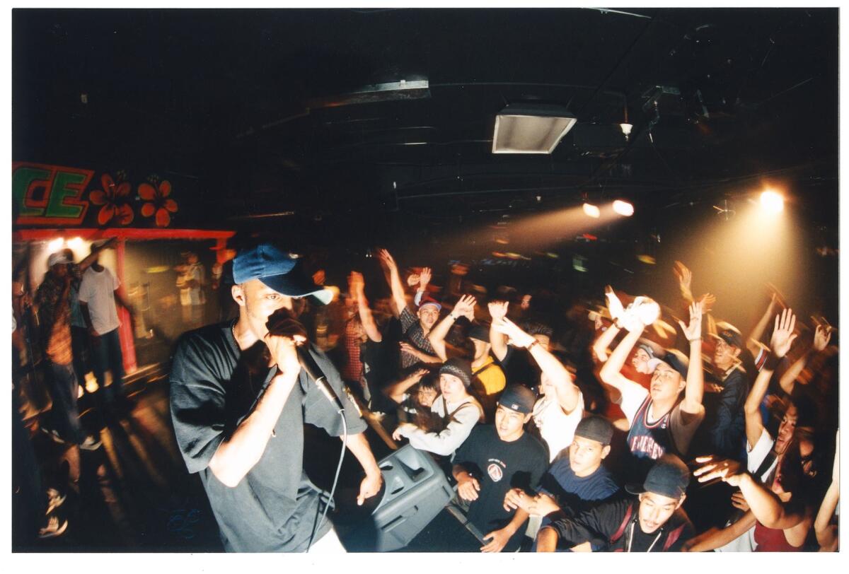 A vintage photo of a DJ with a crowd of people looking up at him