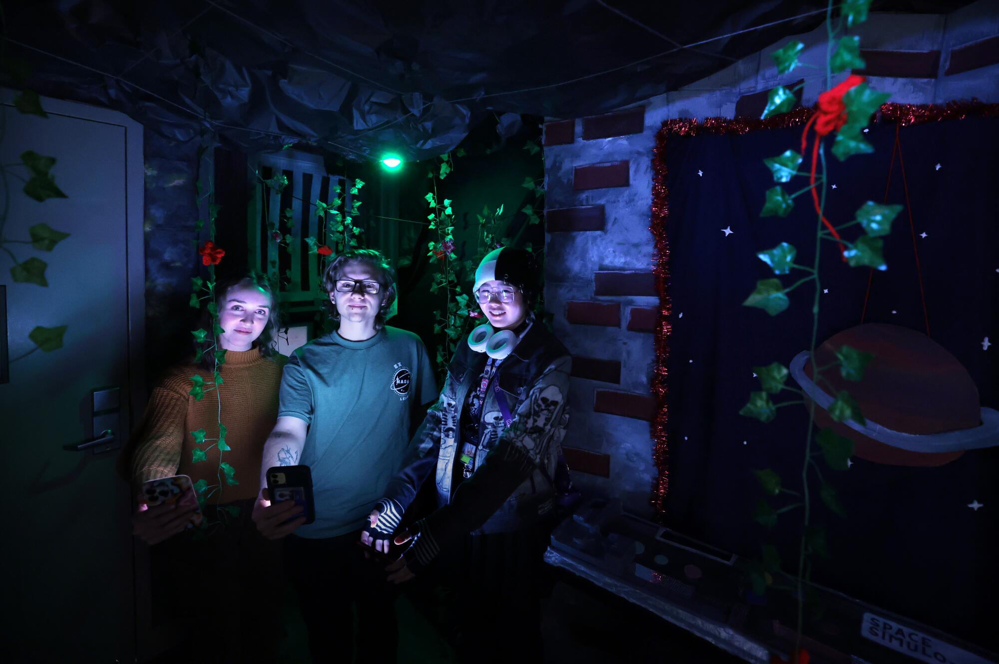 Tyler Neufeld and two of his friends in his darkened escape room.