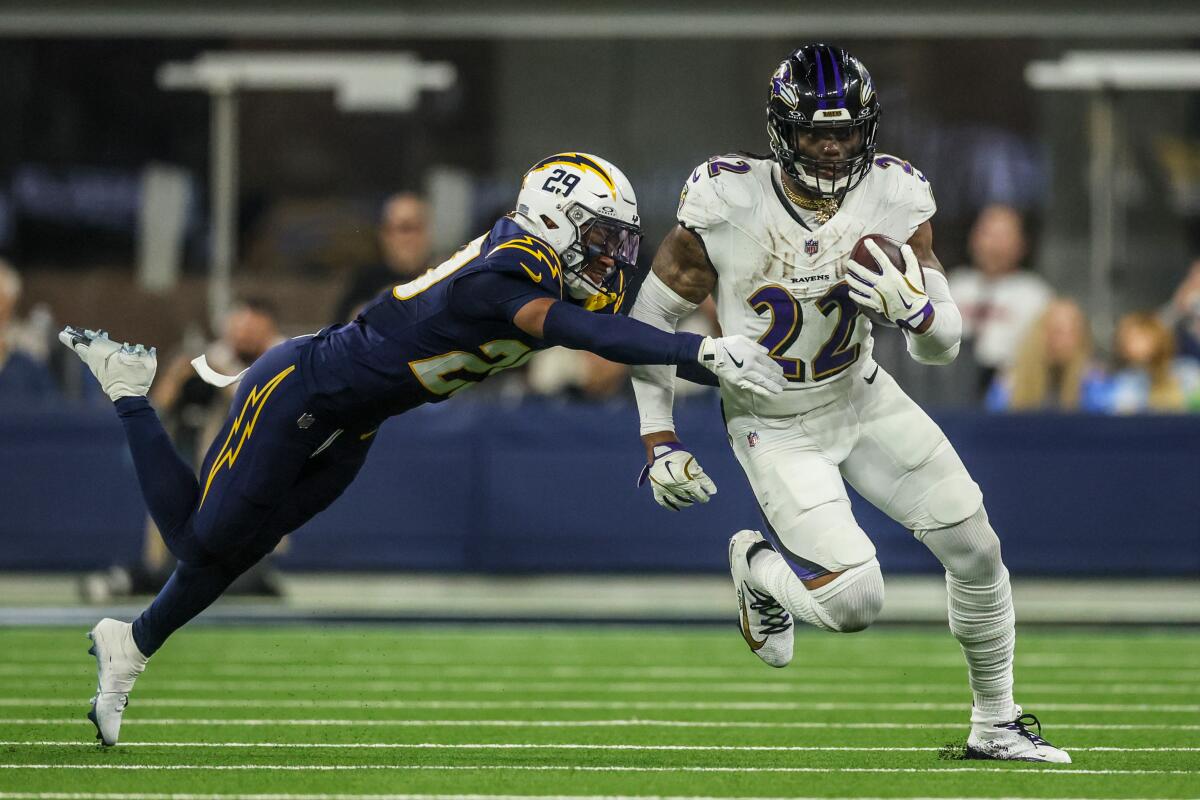 Ravens running back Derrick Henry races past Chargers cornerback Tarheeb Still during the second half.