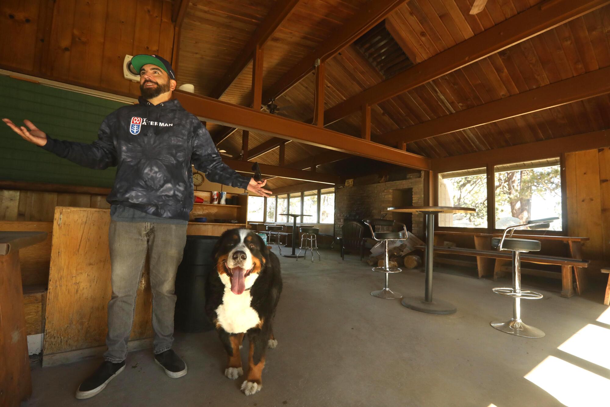 Joshua Shelton stands with his dog in a rustic building