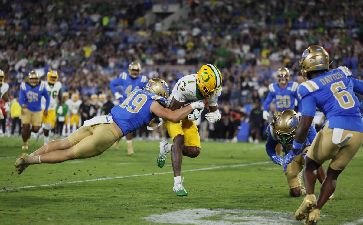 UCLA linebacker Carson Schwesinger leaps to Oregon wide receiver Traeshon Holden as he runs in a touchdown on Sept. 28.