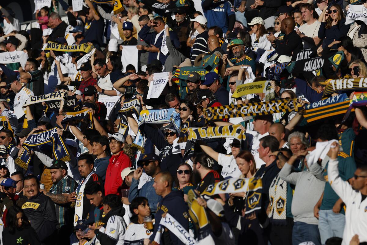 Galaxy supporters wave scarves with their team colors before the team's win over Minnesota United on Nov. 24.