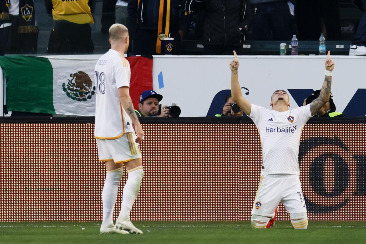 The Galaxy's Gabriel Pec kneels and raises his arms to celebrate with teammate Marco Reus after scoring