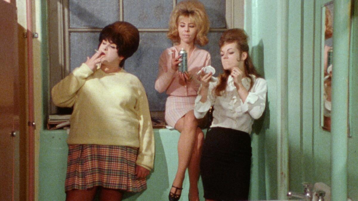 Three women smoke in a bathroom.