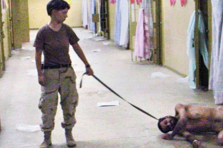 Lynndie England and prisoner at Abu Ghraib prison, Baghdad