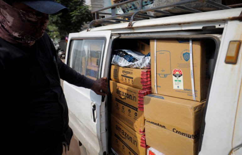 A worker sorts delivery packages in a van outside an Amazon facility in Ahmedabad, India, October 5, 2021. Picture taken on October 5, 2021. To match Special Report AMAZON-INDIA/RIGGING REUTERS/Amit Dave