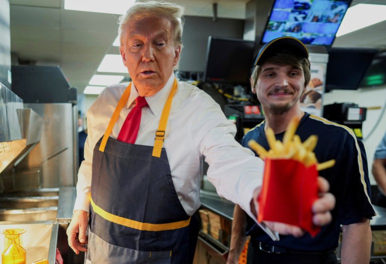 Donald Trump hands fries to someone during a campaign stop at a McDonald's