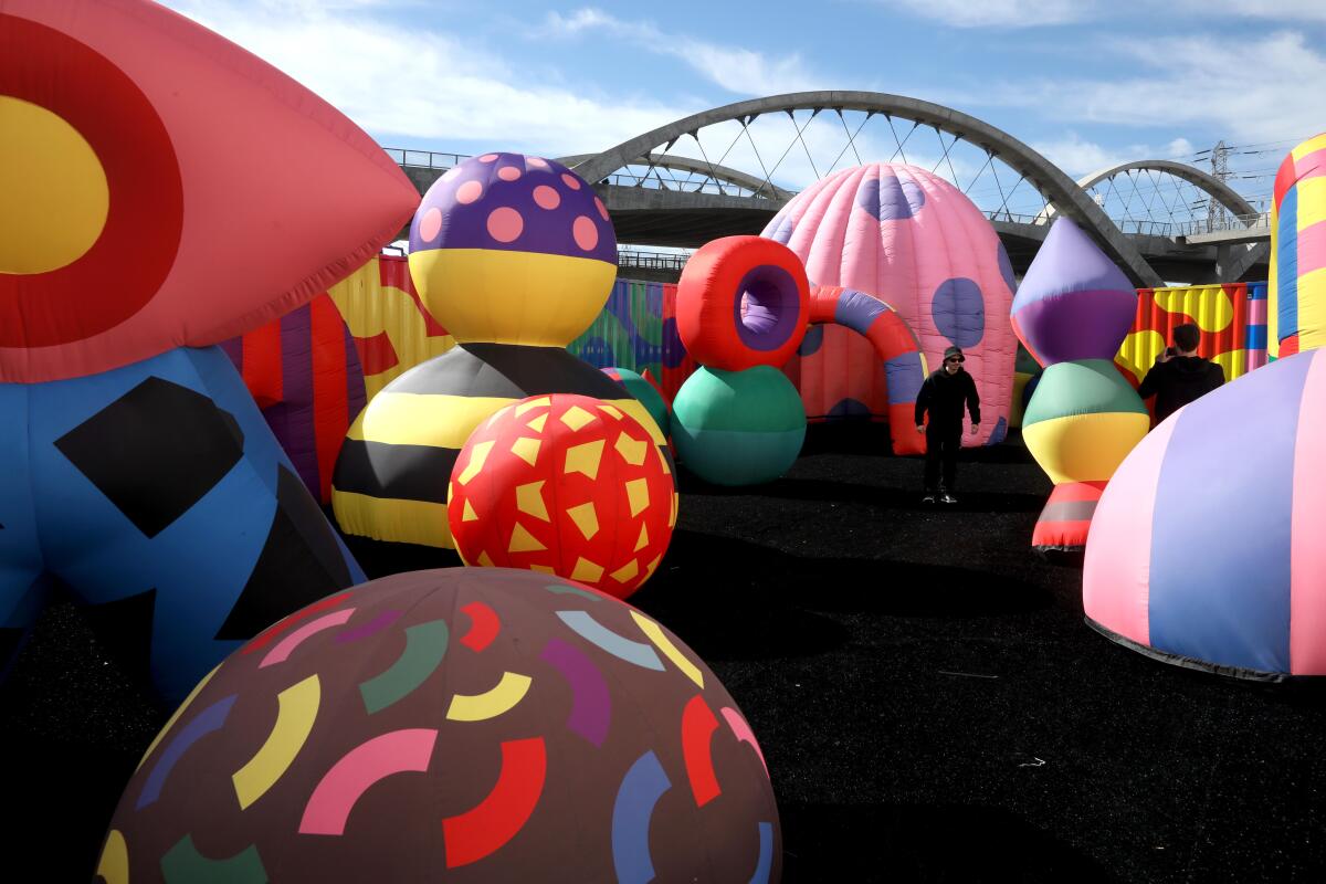 Colorful inflated shapes outdoors with the Sixth Street Viaduct in the background