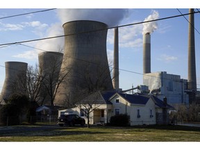 Homes in front of the John E. Amos coal-fired power plant in Poca, West Virginia, U.S., on Friday, Feb. 11, 2022. Coal consumption has surged, while production climbed 8% in 2021 after years of declines. It's expected to inch upward through 2023, according to the Energy Information Administration.