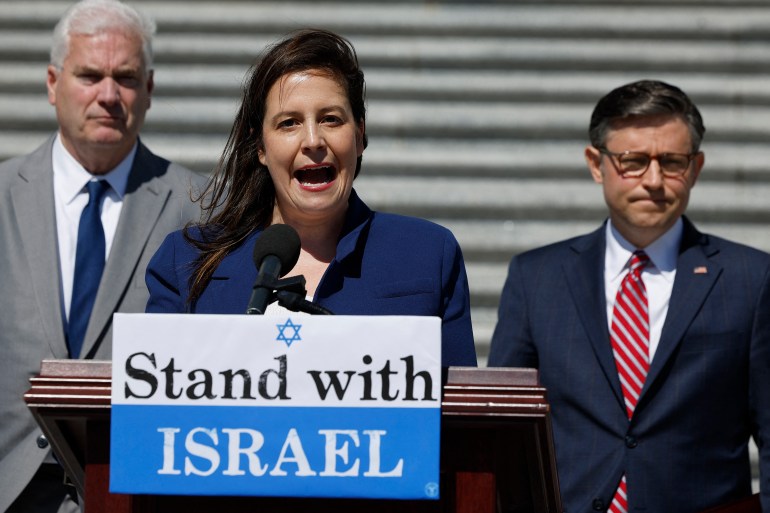 a woman makes a speech behind a podium that says 'stand with israel'