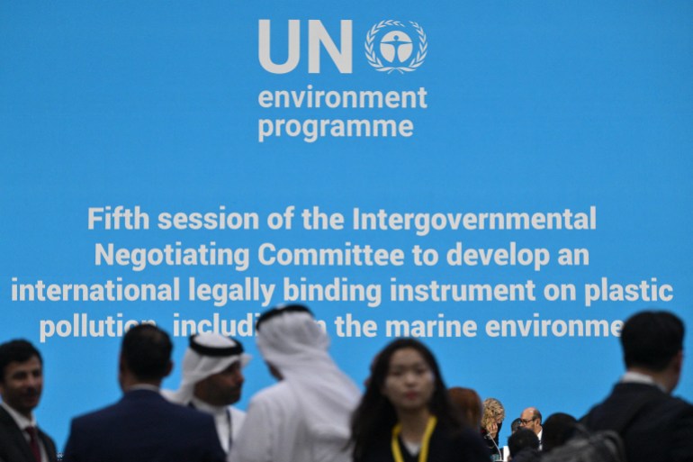 people stand in front of a light blue sign at a conference