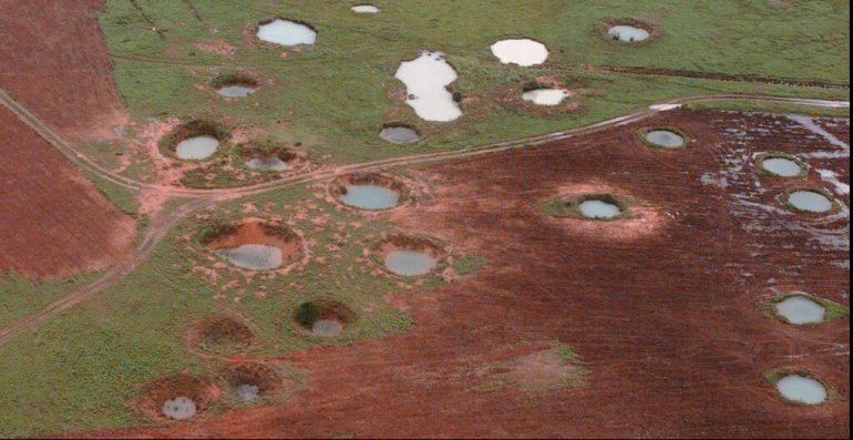 What appears to be ponds are actually water-filled bomb craters from the Vietnam War era, as seen from a helicopter, May 25, 1997, near the northeastern Laotian village of Sam Neau. There are 455 Americans still missing in action from the Laotian theater of the Vietnam War. Teams have been working systematically in Laos from the north, where the Pathet Lao caves are located, all the way down to the Ho Chi Minh trail in the south. (AP Photo/David Longstreath)