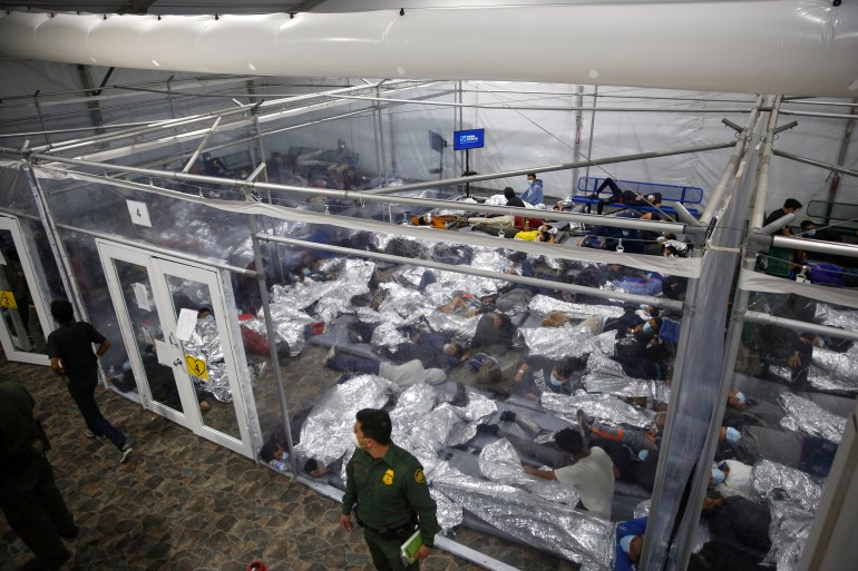 Young migrants are held in a fenced off area