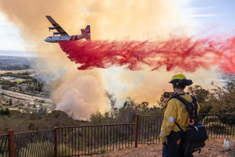 A CALFire firefighting aircraft drops retardant on the Keller Fire in Oakland, Calif., on October 18. Crews now are fighting the Mountain Fire in Ventura County, and firefighters are using similar air tankers to try to beat back the flames. Photo by Peter DaSilva/UPI