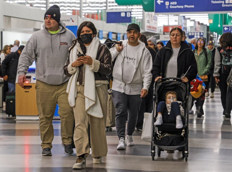 People arrive to check in for flights the day before the Thanksgiving holiday at O'Hare International Airport in Chicago, Ill., on Wednesday. Officials estimate that nearly 80 million people will take to the skies and roads as people travel to spend the holiday with friends and family. Photo by Tannen Maury/UPI