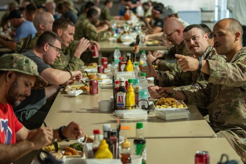 Service members enjoy a traditional Thanksgiving meal after the Defense Logistics Agency delivered 700,000 pounds of food for a holiday feast. Photo by Rose Gudex/U.S. Air Force/Stars and Stripes