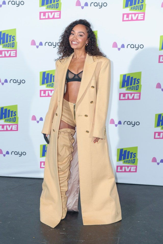 Little Mix's Leigh-Anne Pinnock posed in cowboy-style legwear, hotpants and matching beige overcoat