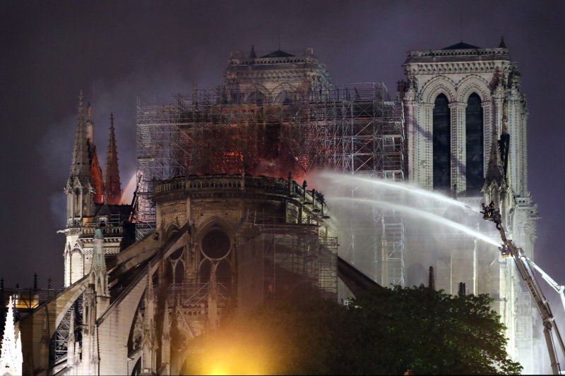 Firefighters battle to extinguish a giant fire that engulfed Paris' Notre Dame Cathedral in 2019. The landmark is set to reopen next week after six years of restoration. File Photo by Eco Clement/UPI