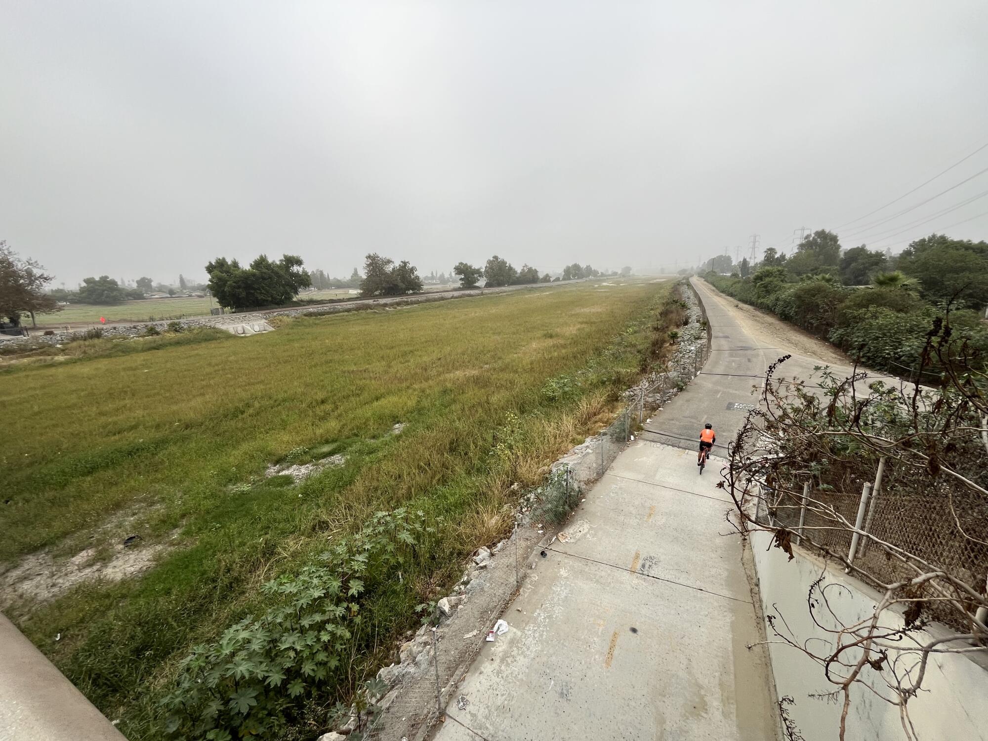 A cyclist rides along the San Gabriel River trail near Pico Rivera.