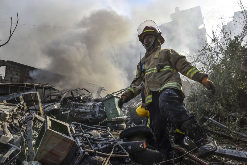 A firefighter stands amid the smouldering debris at the site of overnight Israeli airstrikes that targeted the neighbourhood of Kafaat in Beirut's southern suburbs, on Friday on Nov. 1. On Wednesday, Israel said it again targeted Hezbollah targets in suburbs south of Beirut. Photo by Fadel Itani/UPI