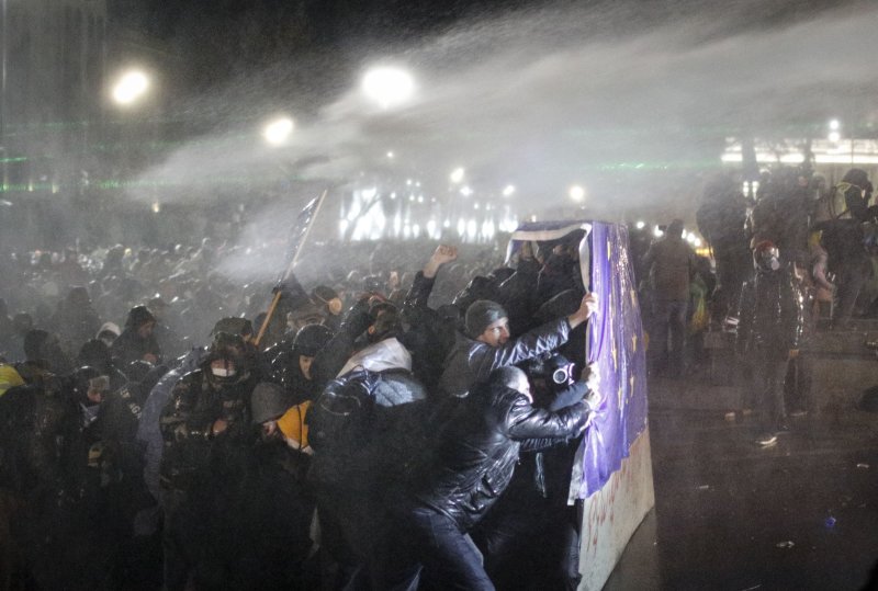 Police use water cannons and tear gas to disperse Georgian opposition supporters as they protest in front of the Parliament building in Tbilisi, Georgia, on Friday. Georgian Prime Minister Irakli Kobakhidze said on Thursday that Tbilisi will refuse EU accession talks until 2028. Photo by David Mdzinarishvili/EPA-EFE