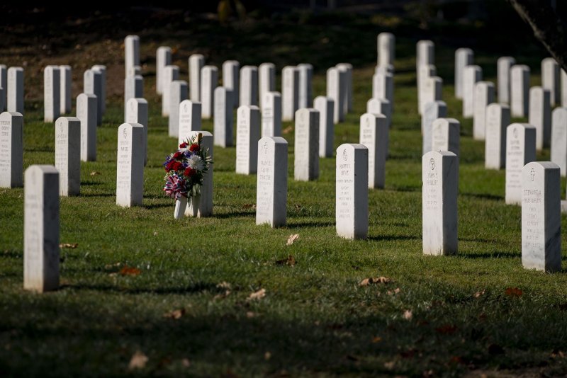 Flowers rest against a tombstone on Veterans Day at Arlington National Cemetery in Arlington, Va. Photo by Bonnie Cash/UPI