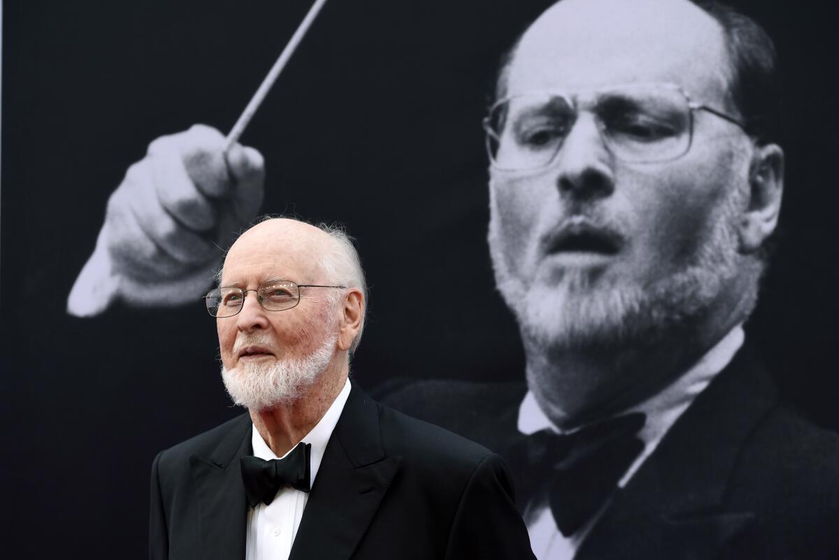 John Williams standing in front of a photo of himself