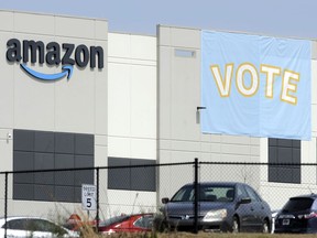 FILE - In this March 30, 2021 file photo, a banner encouraging workers to vote in labor balloting is shown at an Amazon warehouse in Bessemer, Ala.