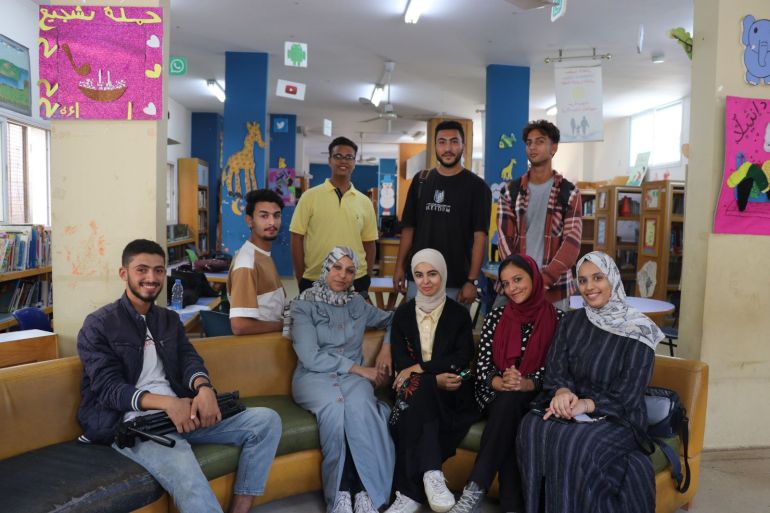 A photo of young women and men sitting on a sofa in a library