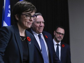 Quebec Premier Francois Legault, flanked by Quebec Immigration Minister Christine Frechette, left, and Quebec Minister Responsible for Canadian Relations and the Canadian Francophonie Jean-Francois Roberge walks in at a news conference on immigration and French language, Wednesday, November 1, 2023 at the legislature in Quebec City.