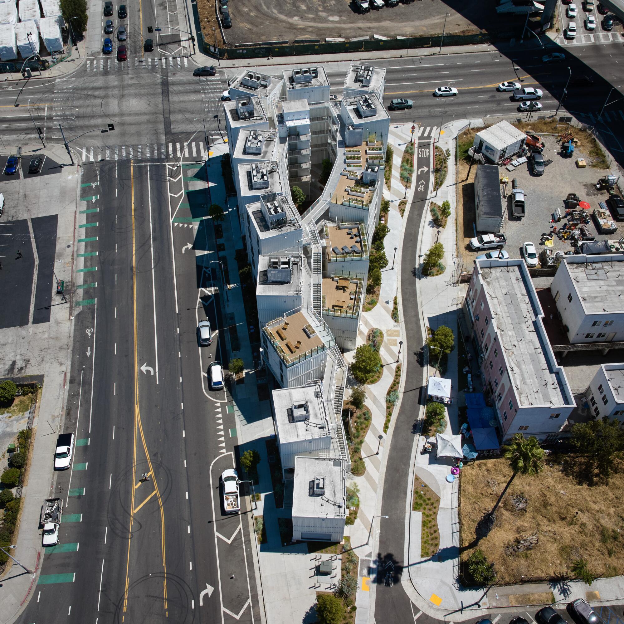 An aerial view of a new housing develop set on a wedge of land near two freeways.  