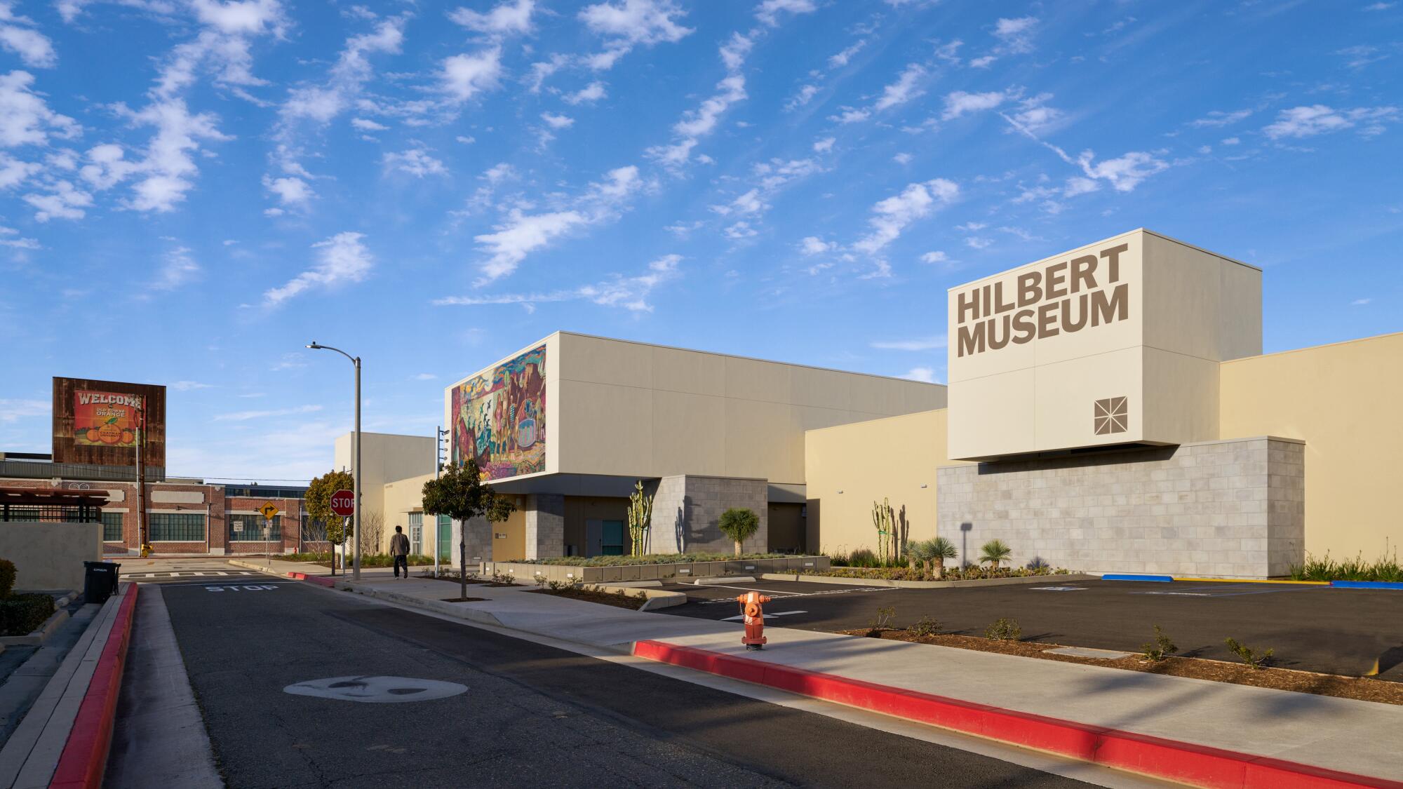 A low-slung building labeled Hilbert Museum welcomes visitors with a massive mosaic artwork.  