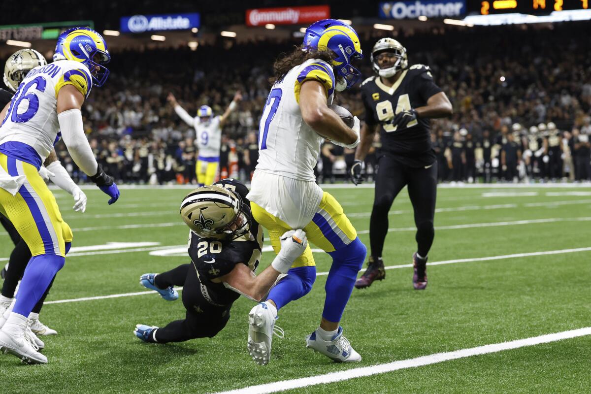 The Rams' Puka Nacua scores the deciding touchdown despite a tackle attempt by the Saints' Pete Werner (20).