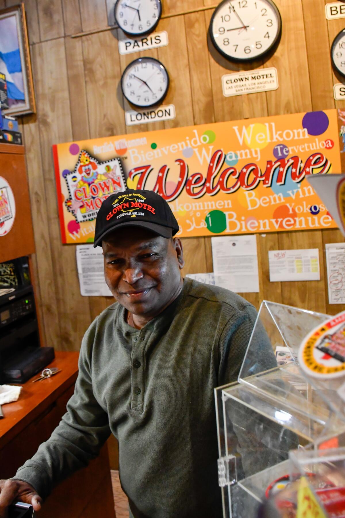 A man stands behind a motel counter.