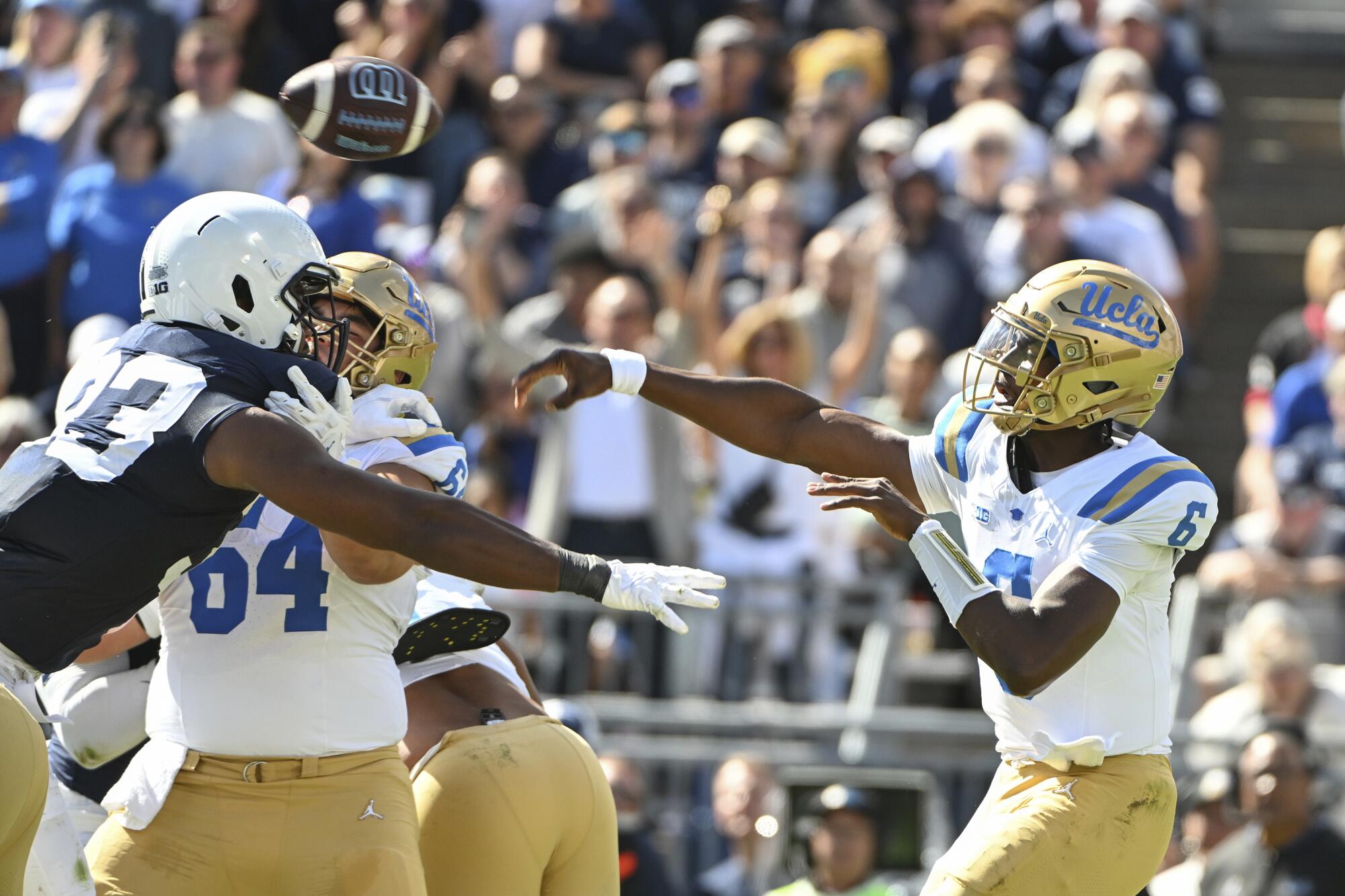 UCLA quarterback Justyn Martin throws a pass while being pressured by Penn State defensive end Dani Dennis-Sutton.