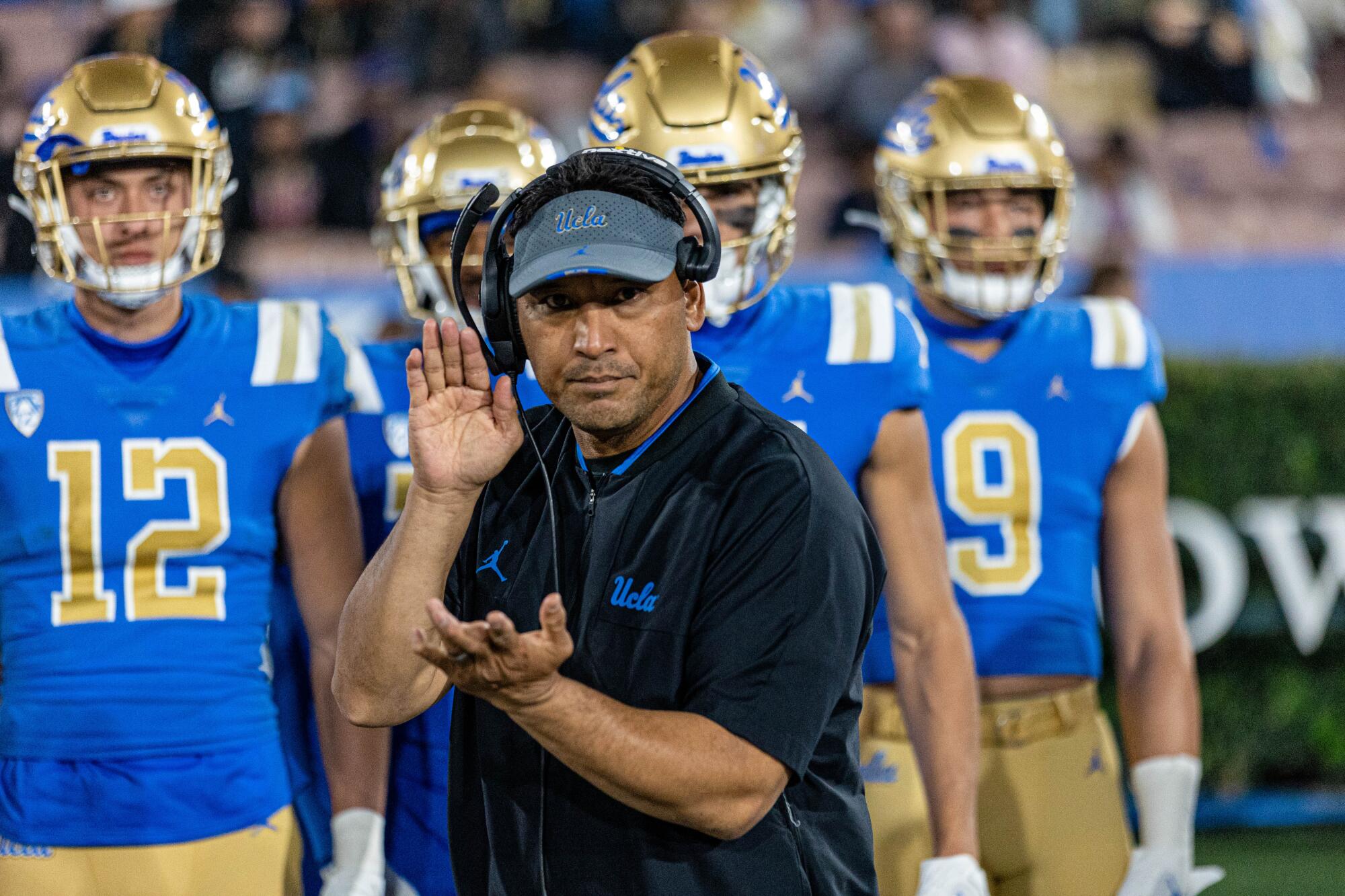 UCLA defensive coordinator Ikaika Malloe claps for his unit while on the sideline.