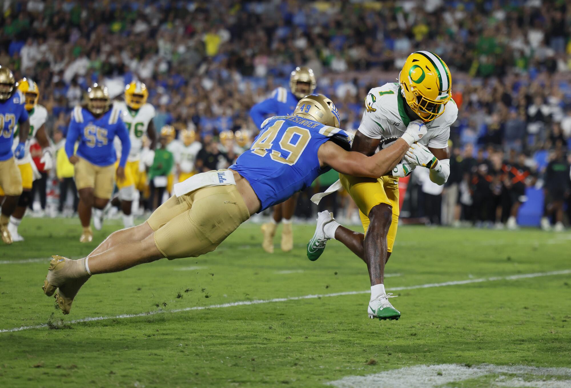 UCLA linebacker Carson Schwesinger tries to stop Oregon receiver Traeshon Holden on a run.