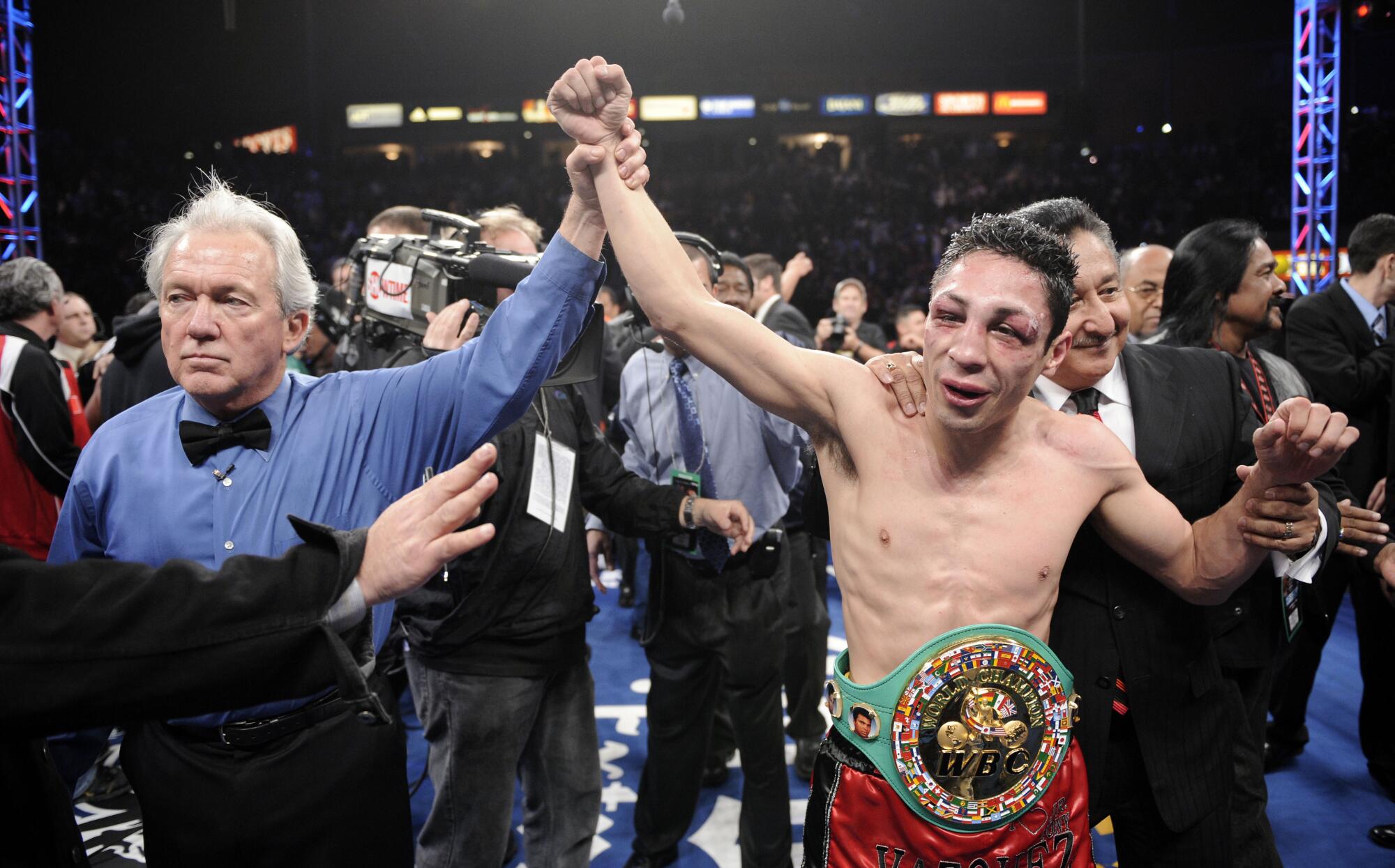 Referee Pat Russell raises the arm of Mexico's Israel Vázquez after he defeated Rafael Márquez in Carson