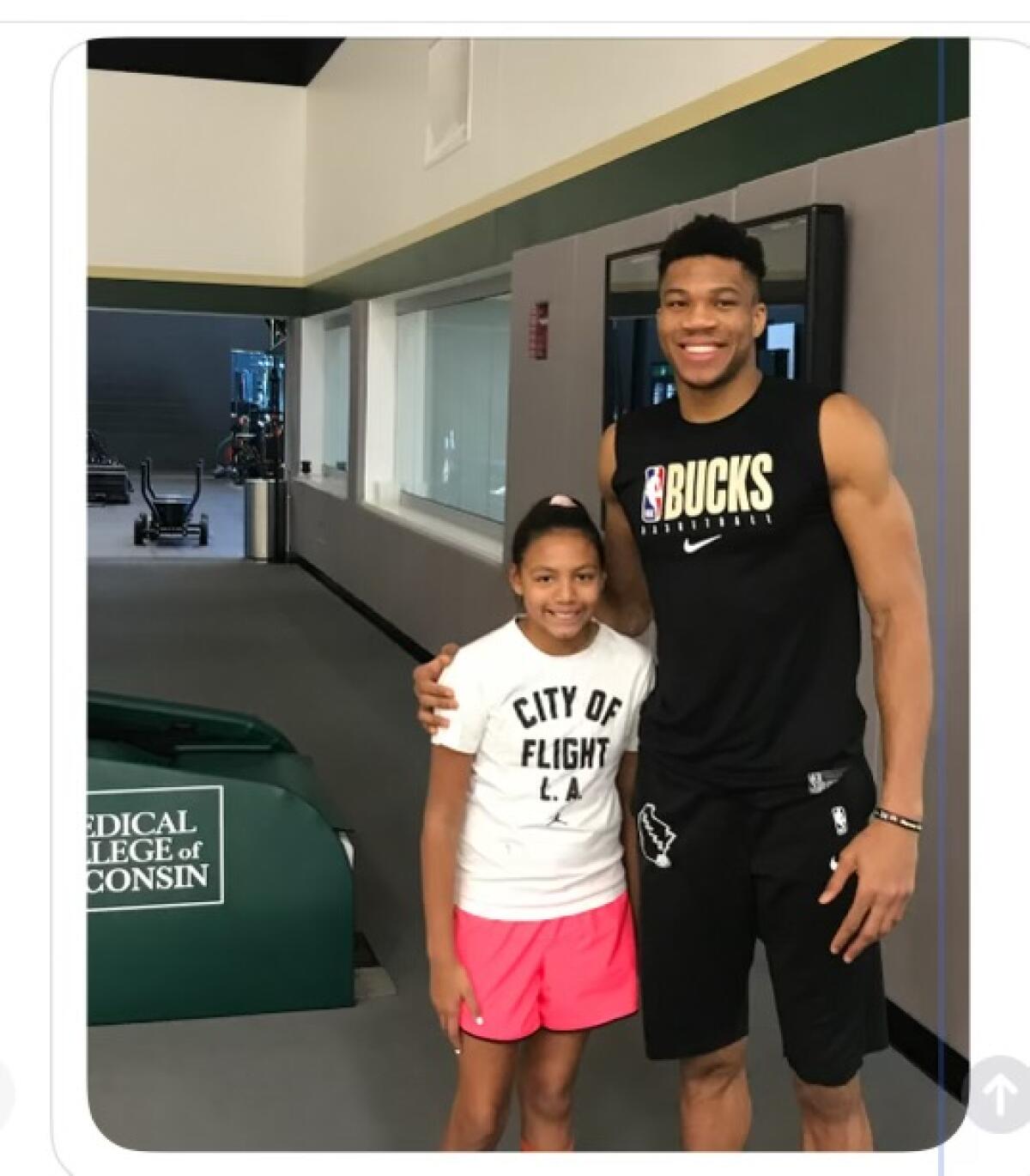 Windward freshman Shiloh Johnson poses for a photo with the Bucks' Giannis Antetokounmpo.