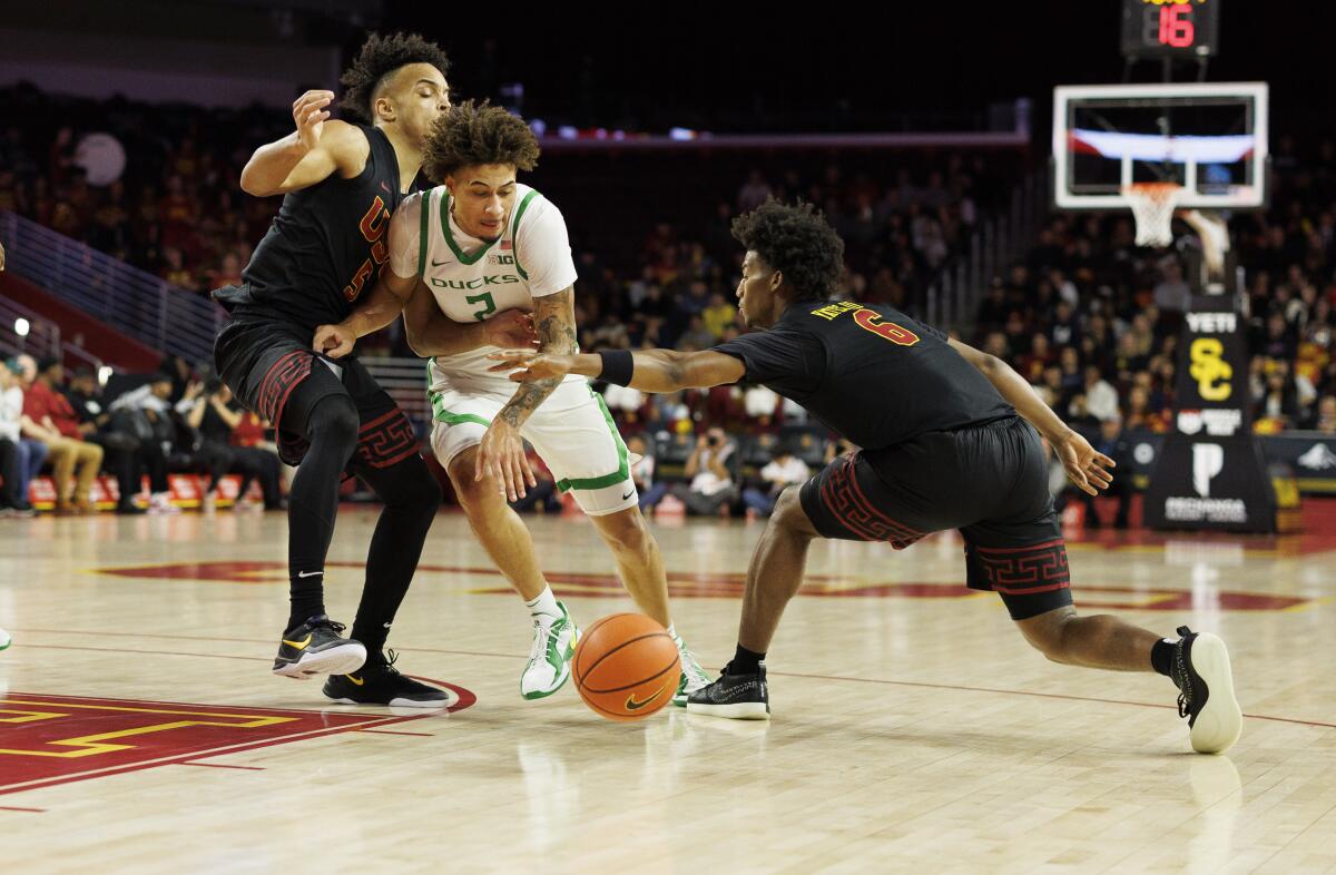 USC forward Terrance Williams II and guard Wesley Yates III try to steal the ball away from Oregon guard Jadrian Tracey.