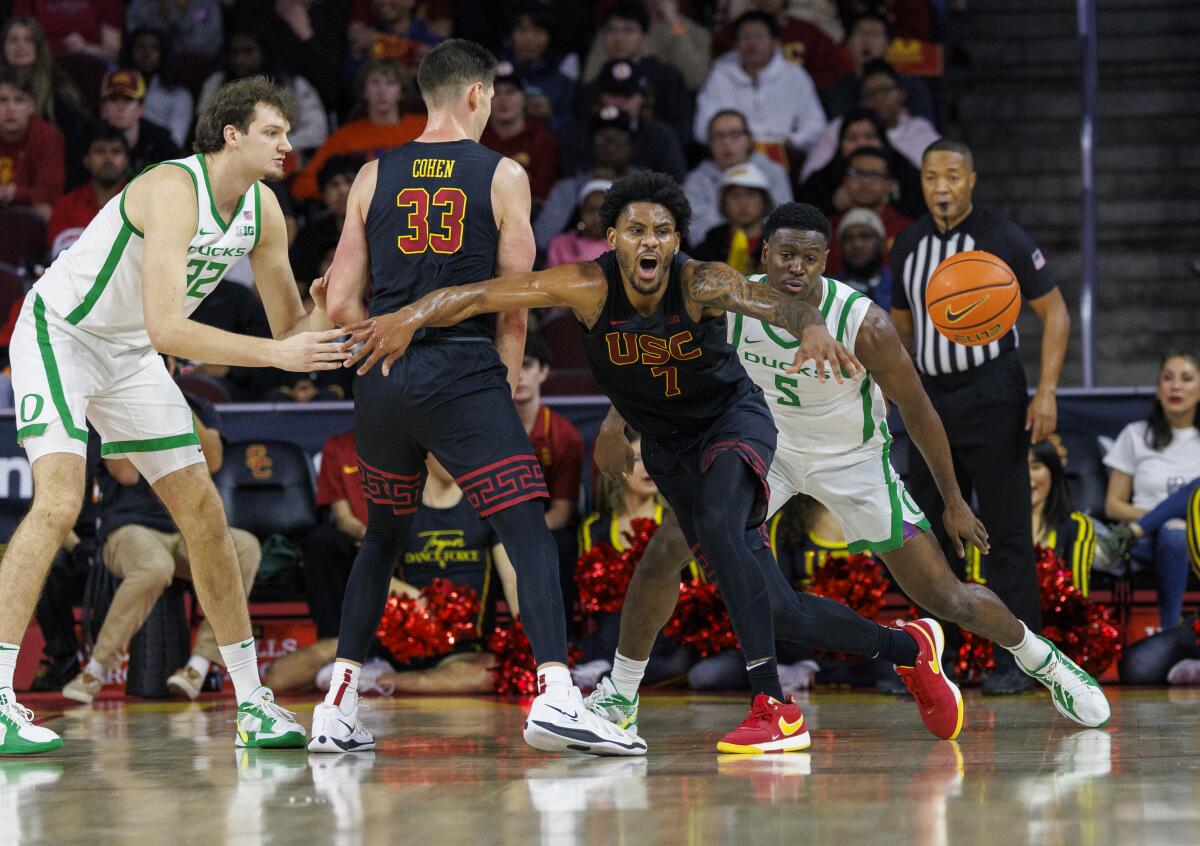 USC guard Chibuzo Agbo, center, steals the ball from Oregon guard TJ Bamba at Galen Center.