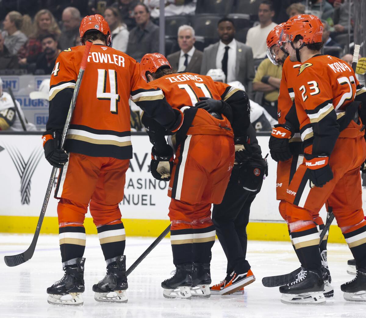 Ducks forward Trevor Zegras is helped off the ice after sustaining a lower-body injury against Vegas.